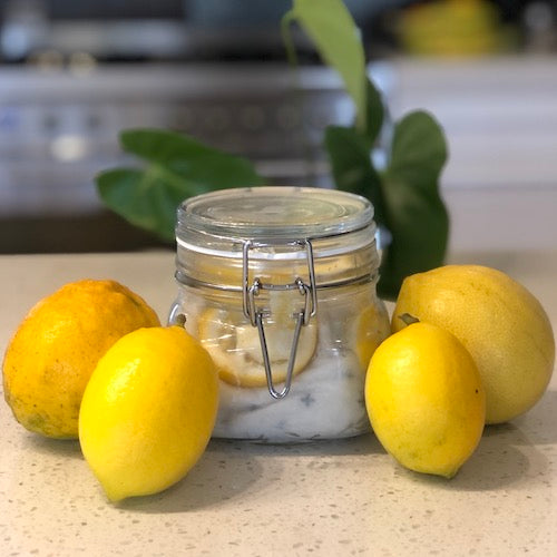 homemade lemon dusters in a jar with lemons