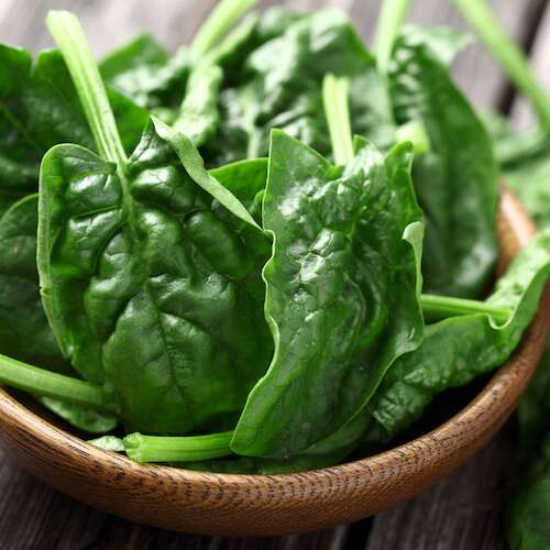 Spinach leaves on a wooden plate