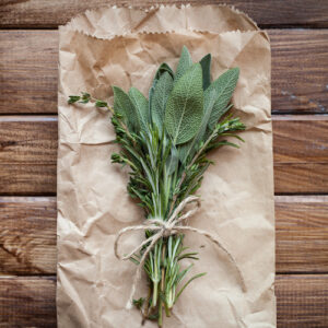 Tied sage leaves and herbs on a wooden background