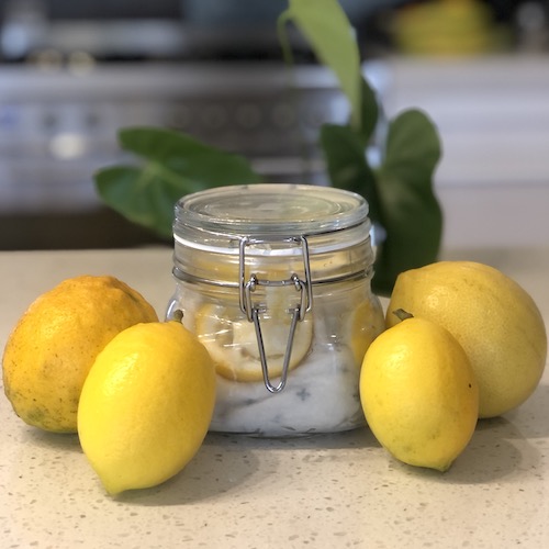 homemade lemon dusters in a jar with lemons