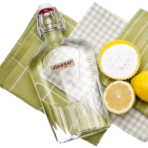 white cleaning vinegar with lemons