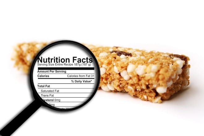 Muesli bar with nutrition facts in magnifying glass