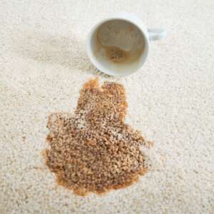 Close-up of coffee spilling from cup on carpet