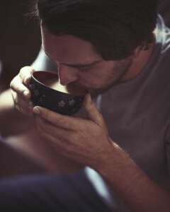 man drinking kava out of coconut bowl