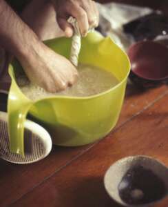 kava being strained into a bowl