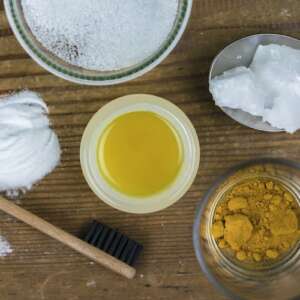 DIY toothpaste with ingredients, coconut oil, turmeric, baking soda, and bamboo toothbrush