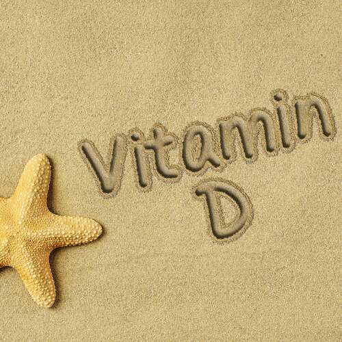Vitamin D text on sand and starfishes