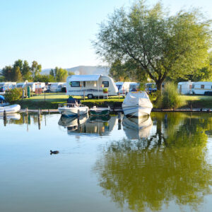 Camping site on a lake with caravans and boats