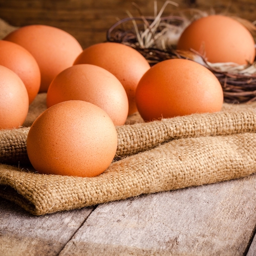 Fresh farm eggs on a wooden rustic background